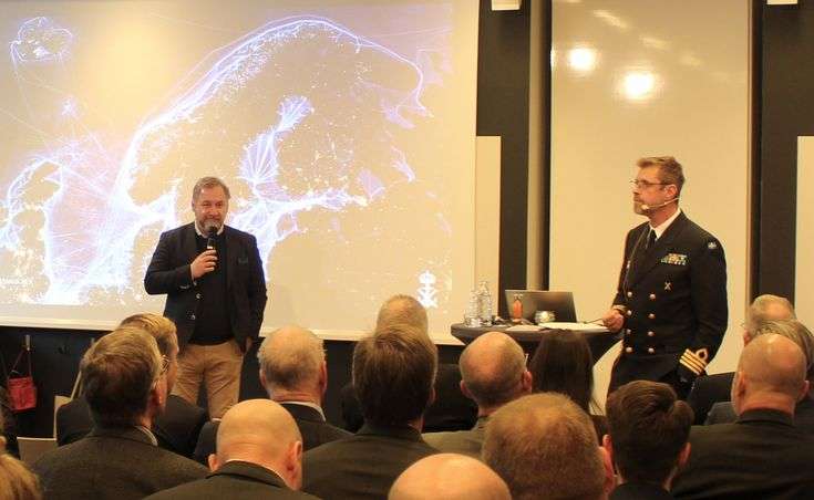 Freddy Jönsson Hanberg talar inför en grupp människor tillsammans med en man i uniform.