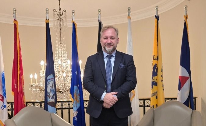 Freddy Jönsson Hanberg framför en rad med flaggor på Army Navy Club.